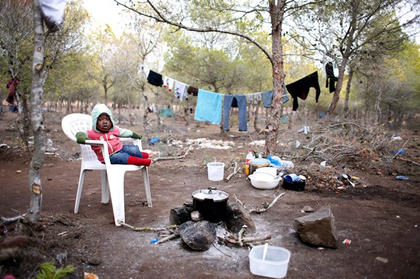 Un bebé llamado Kader se sienta en una silla de plástico en un campamento clandestino de migrantes africanos llamado Bolingo en el norte de Marruecos, cerca de la valla fronteriza con el enclave español de Melilla, al norte de África, 28 de noviembre de 2013 | Foto: Juan Medina (Reuters)